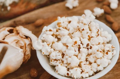 Kulhollinen popcorn-kaloritia sekoitettuna manteleihin ja valkosipuliin, joka esittelee suolaisen välipalasekoituksen.
